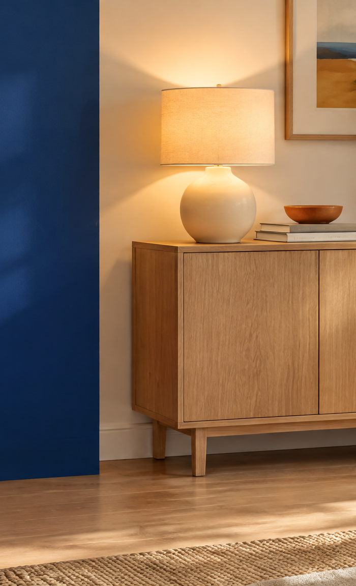 Bright living room with oak sideboard, table lamp and blue throw